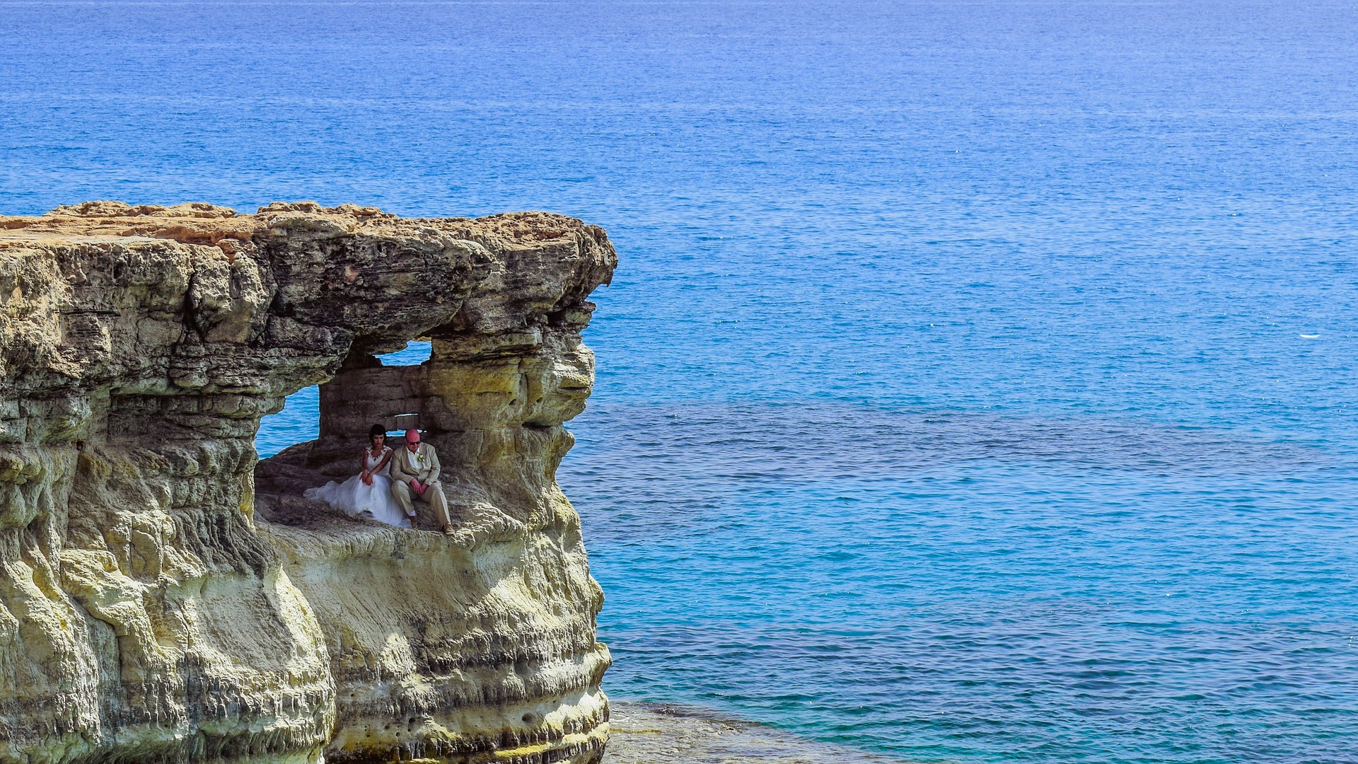 Couples in rocky bluff overlooking ocean